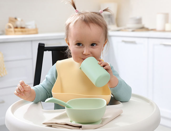 9 - 12 month old kid drinking out of a sippy cup.